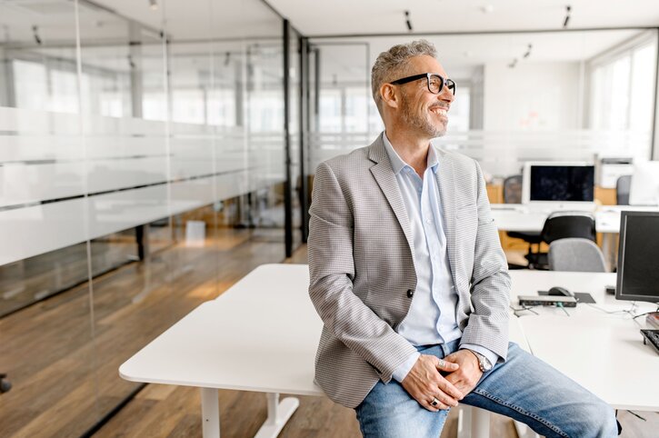 Homme assis sur un bureau - Assurance pour entreprises - Choix de produits d'assurance - Ellipse Assurances