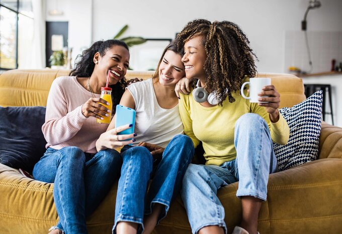 Femmes sur un sofa discutant et riant - Fondation Ellipse - Remplir une demande - Ellipse Assurances
